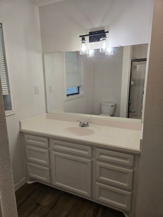 Bathroom with wood finished floors, vanity, and a shower with door | Image 13