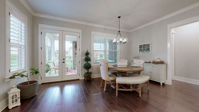 Bright, airy, and full of charm—this breakfast nook offers the perfect spot for morning coffee, featuring plantation shutters, elegant lighting, and French doors that open to the screened-in porch. | Image 20