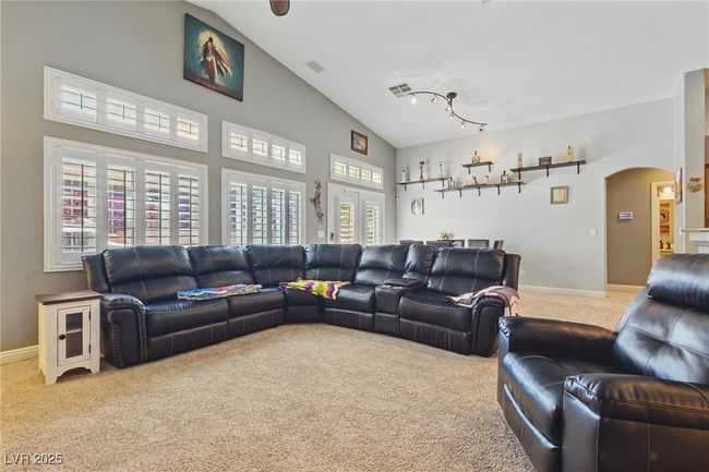 Living room featuring visible vents, arched walkways, baseboards, carpet flooring, and high vaulted ceiling | Image 10