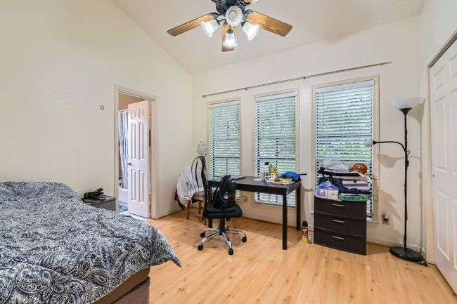 Bedroom featuring wood finished floors, a ceiling fan, and high vaulted ceiling | Image 15