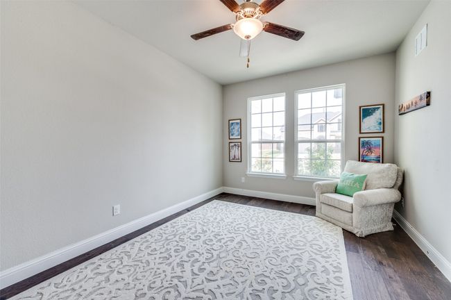 Living area featuring dark wood-style flooring, visible vents, ceiling fan, and baseboards | Image 23