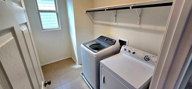 Laundry area featuring independent washer and dryer and light tile patterned floors | Image 29