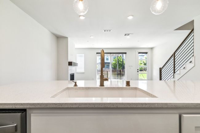 Kitchen with open floor plan, light stone countertops, dishwashing machine, and recessed lighting | Image 16