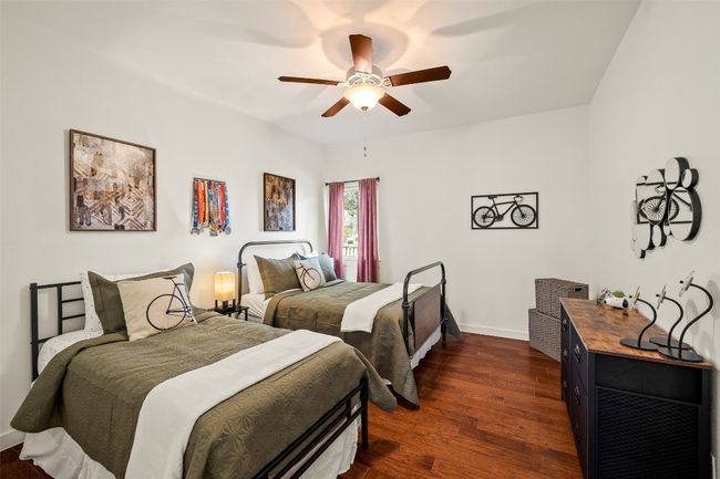 Bedroom with dark wood-style flooring and ceiling fan | Image 21