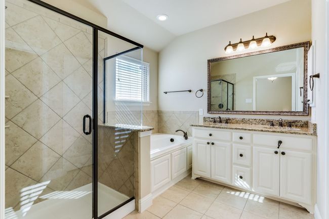 Full bath featuring a garden tub, double vanity, tile patterned floors, a shower stall, and lofted ceiling | Image 24