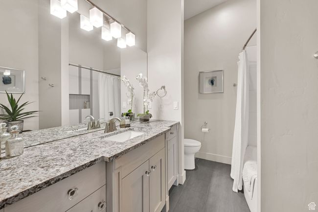 Full bathroom with vanity, toilet, baseboards, and shower / bath combo | Image 53