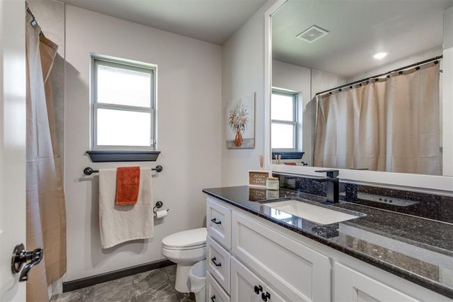 Full bathroom with a shower with curtain, visible vents, vanity, and toilet | Image 13