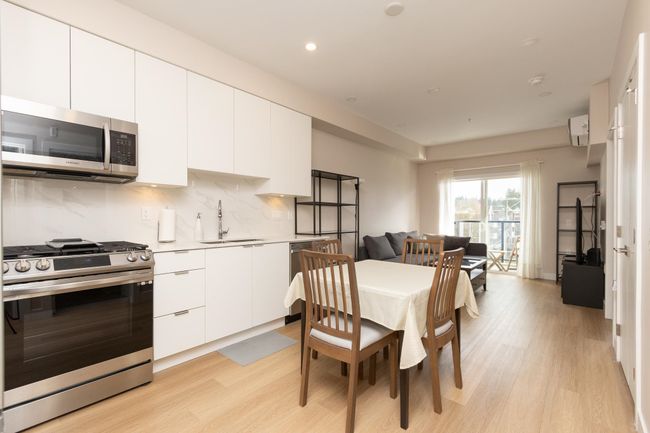 Dining area featuring a wall mounted AC, light wood-style flooring, and recessed lighting | Image 5
