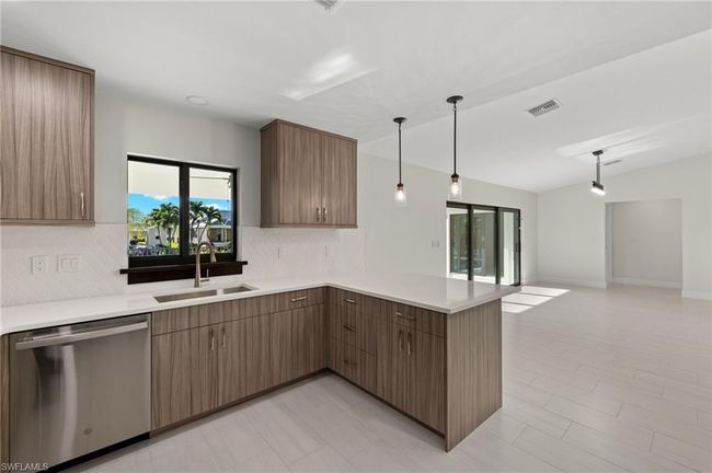Kitchen featuring light tile patterned flooring, tasteful backsplash, kitchen peninsula, dishwasher, and pendant lighting | Image 18