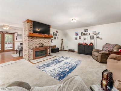 Living room featuring a brick fireplace, carpet floors, and ceiling fan | Image 3