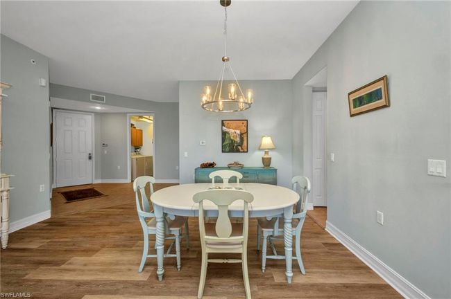 Dining area with a chandelier and wood finished floors | Image 11
