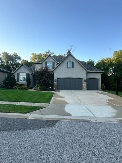 French provincial home featuring a garage and a front lawn | Image 1