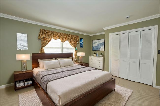 Carpeted bedroom with ornamental molding, a closet, and baseboards | Image 10