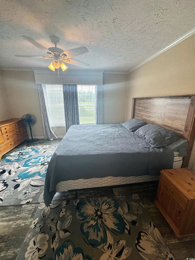 Bedroom with a textured ceiling, ceiling fan, and ornamental molding | Image 18
