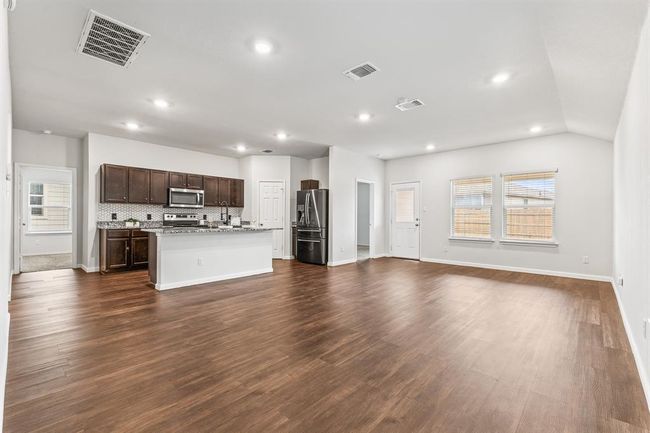 Unfurnished living room featuring plenty of natural light, recessed lighting, and dark wood-style floors | Image 4