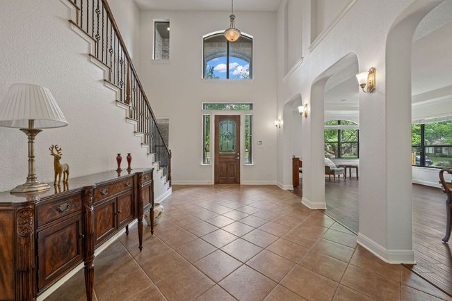 Tiled foyer entrance featuring baseboards, stairs, and arched walkways | Image 5