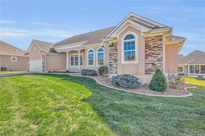 View of front of property with central air condition unit, a garage, and a front lawn | Image 3