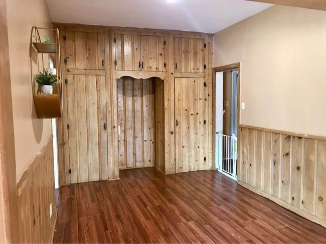 Unfurnished living room featuring wooden walls and wood finished floors | Image 9
