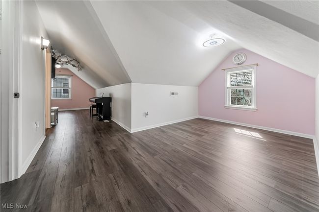 Bonus room with dark wood-type flooring, visible vents, lofted ceiling, and baseboards | Image 25