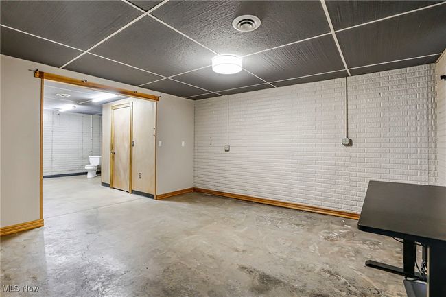 Finished basement featuring brick wall and baseboards | Image 40