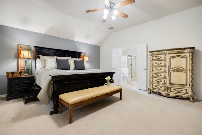 primary bedroom featuring lofted ceiling, ceiling fan, view of the yard, and lots of space. | Image 12