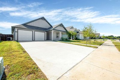 View of front of home featuring a garage, central AC unit, and a front yard | Image 1