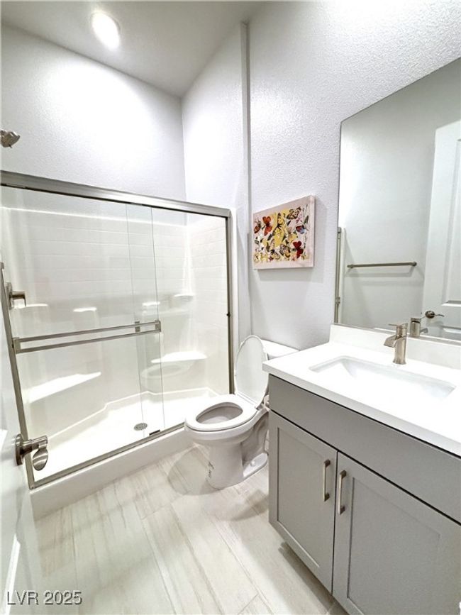 Bathroom featuring a stall shower, toilet, and vanity | Image 32