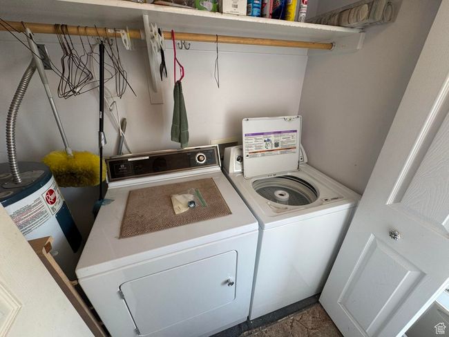 Laundry room featuring independent washer and dryer and water heater | Image 16