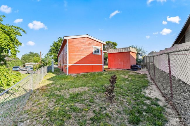 Fenced backyard featuring a storage unit | Image 12