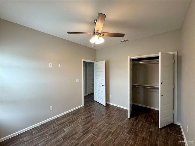 Unfurnished bedroom featuring dark wood-style floors, baseboards, a closet, and ceiling fan | Image 9