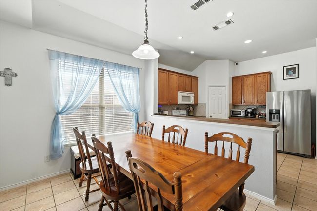 Dining space with lofted ceiling, light tile patterned floors, and recessed lighting | Image 5