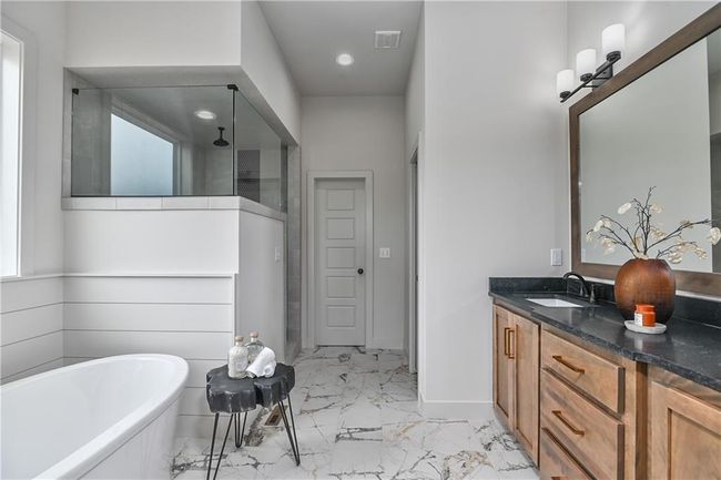 Bathroom with tiled tub, tile patterned floors, and vanity | Image 24