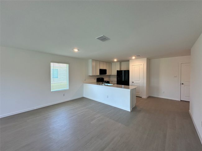 Kitchen with black appliances, dark wood-style flooring, recessed lighting, a peninsula, and baseboards | Image 7
