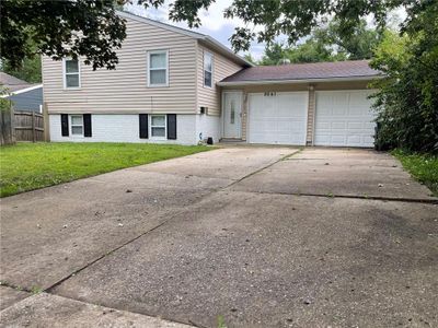 Tri-level home with a front yard and a garage | Image 1