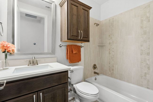 Bathroom with visible vents, tub / shower combination, toilet, and vanity | Image 27