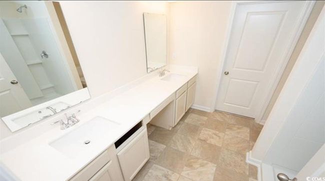 Bathroom featuring double vanity, walk in shower, and a sink | Image 15