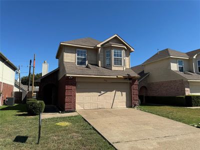 View of front facade with a garage, a front lawn, and central AC | Image 1