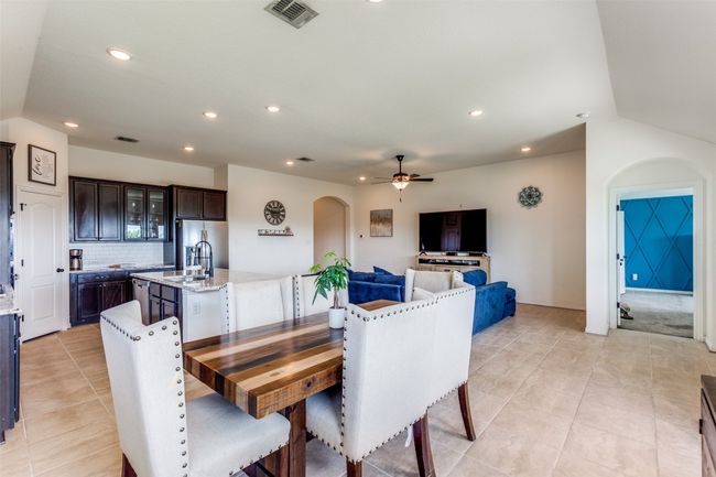 Dining room with arched walkways, ceiling fan, light tile patterned flooring, and recessed lighting | Image 6