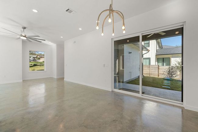 Unfurnished room with visible vents, concrete floors, baseboards, chandelier | Image 9
