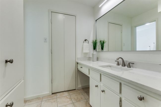 Master bathroom has 2 vanity areas, one side has a space for a makeup area. New Carrera Gold quartz, new mirrors, and new lighting give this area a fresh upscale feeling. Lots more cabinet space on the left, with a large walk-in closet on each side! | Image 20