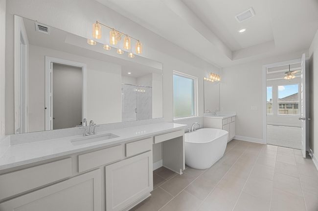 Bathroom featuring a shower stall, baseboards, two vanities, a freestanding bath, and tile patterned floors | Image 19