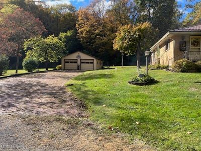 View of yard featuring an outdoor structure and a garage | Image 3