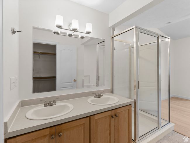 Full bathroom featuring double vanity, a stall shower, and vaulted ceiling | Image 19