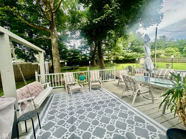 deck featuring a trampoline, outdoor dining area, a fenced backyard, and an outdoor hangout area | Image 13