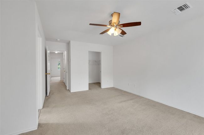 Unfurnished bedroom with light carpet, a spacious closet, a closet, and a ceiling fan | Image 20