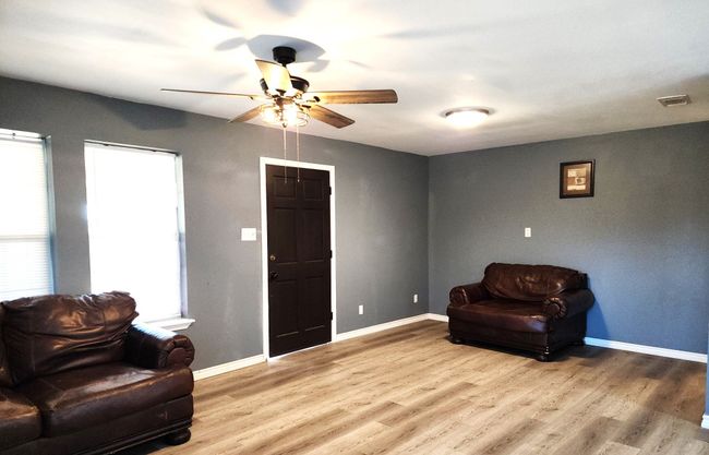 Living area featuring baseboards, visible vents, a ceiling fan, a wealth of natural light, and wood laminate floors | Image 4