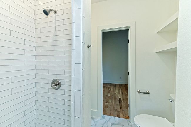Full bathroom featuring a stall shower and toilet | Image 24