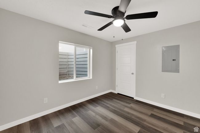 Unfurnished room featuring electric panel, dark wood finished floors, and a ceiling fan | Image 25