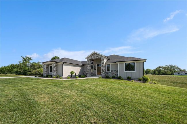 Prairie-style home with stone siding and a front lawn | Image 5