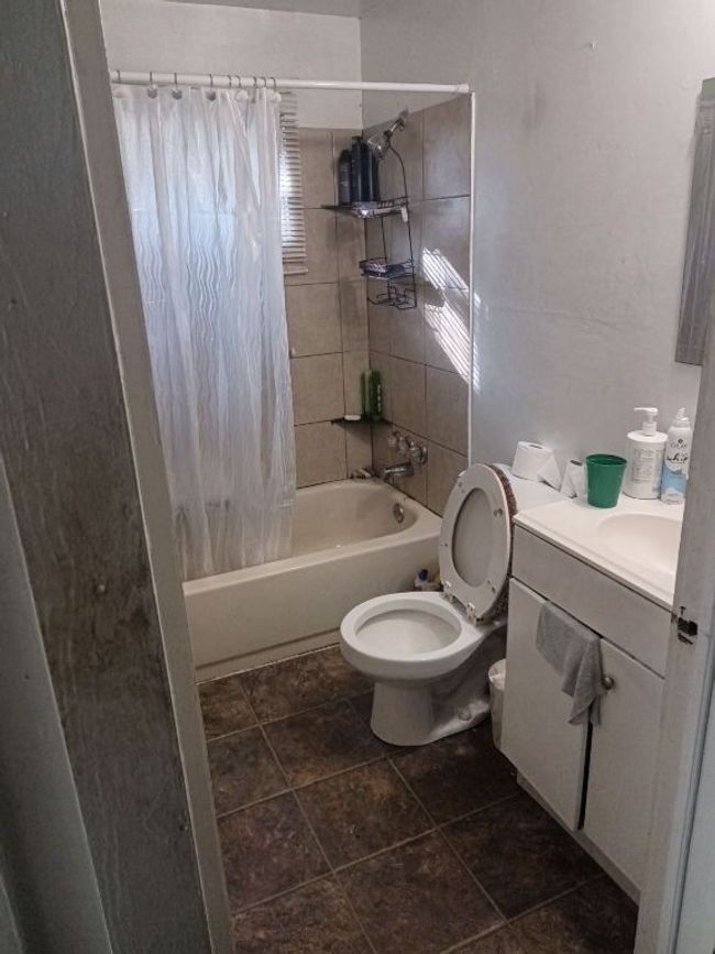 Full bathroom featuring toilet, vanity, and shower / tub combo with curtain | Image 4